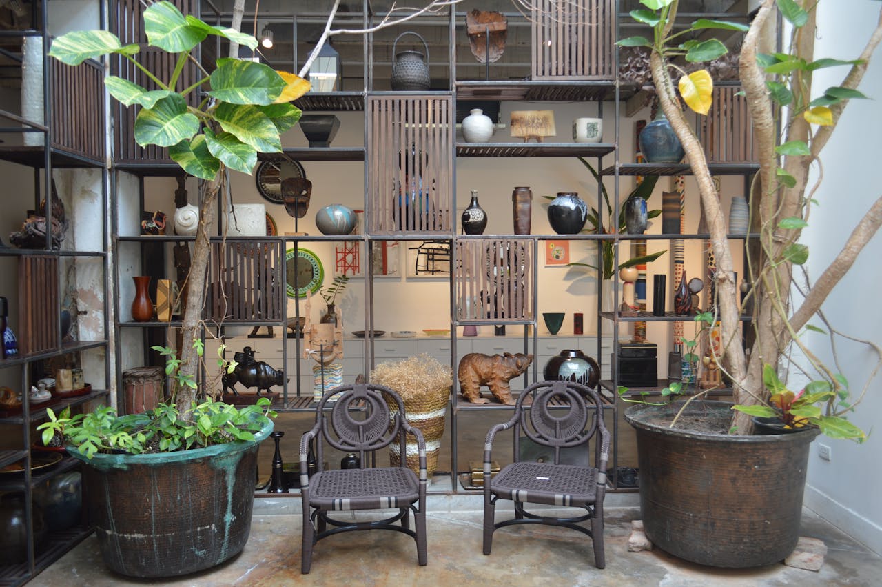 Rustic indoor patio with decorative shelving, pottery, and lush potted plants for a cozy atmosphere.